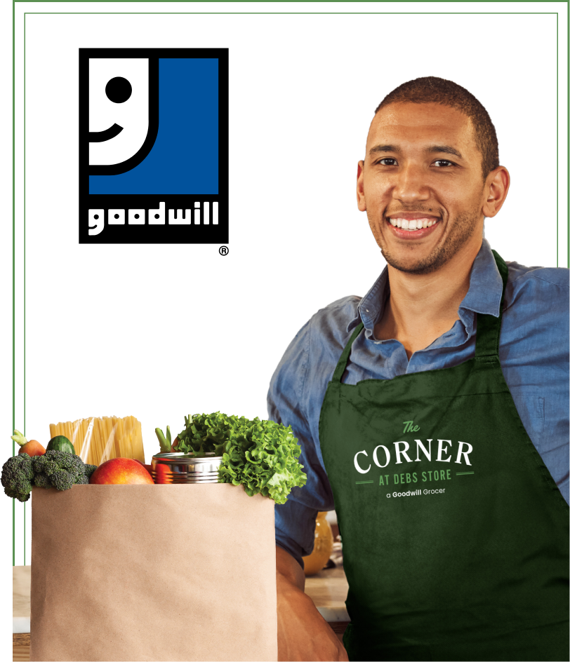 Young man with a green apron holding a paper bag of groceries